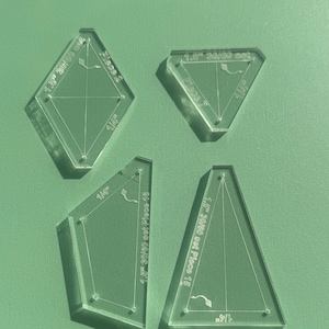 May include: Four clear plastic quilting templates for creating 30/60 degree quilt blocks. The templates are labelled with measurements in inches and include instructions for creating different quilt blocks.