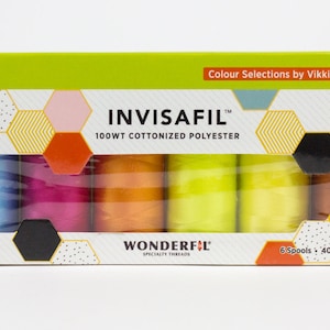 May include: A box of INVISAFIL specialty threads by Vikki Pignatelli. The box is white with a lime green top and geometric designs. It contains six spools of colorful thread, each 400m (437yd) long, in shades of blue, pink, orange, yellow, and brown.