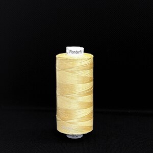 May include: A spool of beige thread with a white label that reads "WonderFil Cotton".