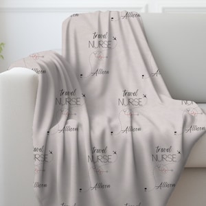 Puede incluir: Una manta suave de color gris claro con un patrón repetido del texto "Travel Nurse" con un corazón y un avión gráfico. El nombre "Allison" está impreso debajo de cada gráfico.