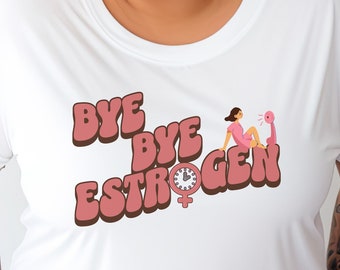 Op de afbeelding: Wit T-shirt met een roze afbeelding met de tekst "Bye Bye Estrogen" met een cartoonvrouw en een klok met een vrouwelijk symbool.