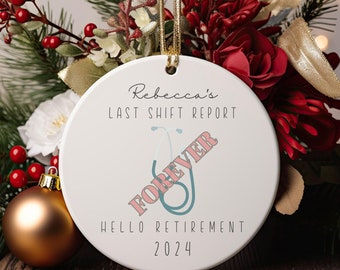 May include: White ceramic Christmas bauble with the text "Rebecca's Last Shift Report" and a stethoscope with the word "Forever" written across it in pink. The bauble also says "Hello Retirement 2024".