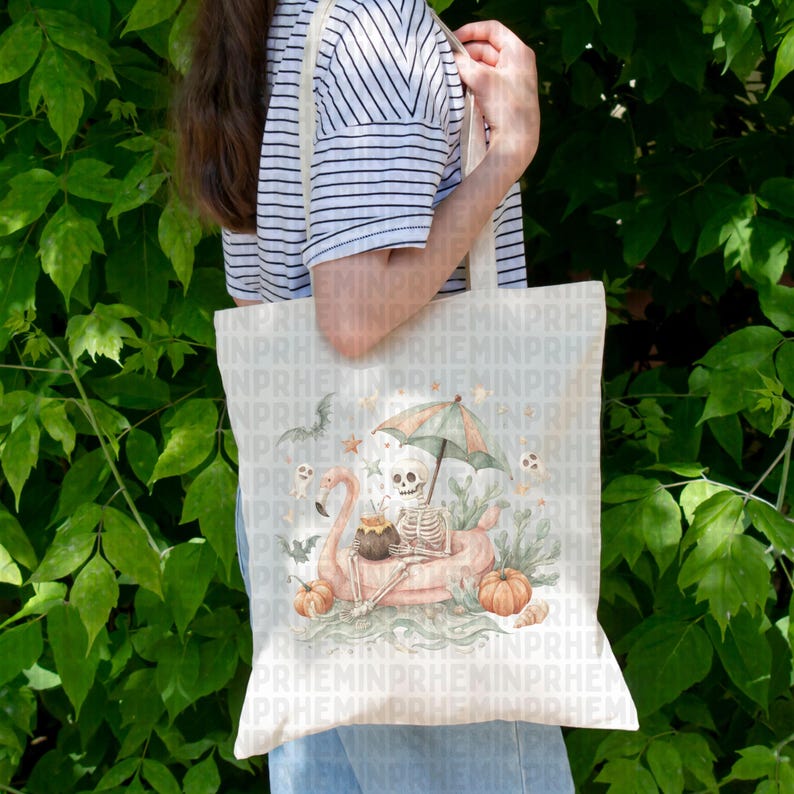 Op de afbeelding: Een cr&egrave;mekleurige draagtas met een Halloween-ontwerp. De illustratie toont een skelet op een roze flamingo-vlot, onder een paraplu, met pompoenen, vleermuizen en geesten. De tas heeft een natuurlijke canvas band.