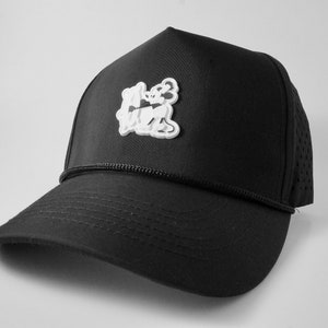 May include: Black mesh trucker hat with a white embroidered logo of two cartoon figures.