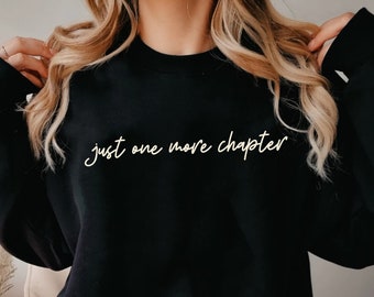 May include: Black sweatshirt with the text "just one more chapter" in white lettering.