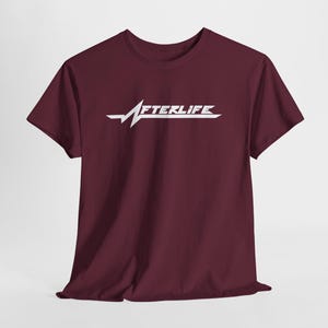 May include: A maroon t-shirt with the word "AFTERLIFE" in white, stylized text. The design includes a white heartbeat-like graphic. The shirt has short sleeves and a crew neck.