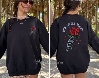 May include: Black sweatshirt with a rose and skeleton hand graphic on the front and the text "Run Little Mouse" on the back.