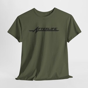 May include: Olive green t-shirt with the word "AFTERLIFE" in black, stylized with a heartbeat-like graphic. The short-sleeved shirt is made of a soft material.