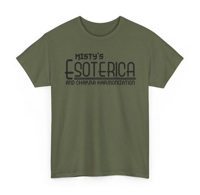 Peut inclure: T-shirt vert olive avec l'inscription noire "Misty's Esoterica and Chakra Harmonization". Le t-shirt a des manches courtes et un col rond. Le texte est centr&eacute; sur le devant du t-shirt.