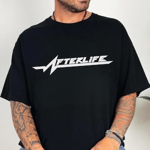 May include: Black t-shirt with the word "AFTERLIFE" in white, stylized text. The design includes a white lightning bolt graphic. The shirt is a short-sleeved, crew neck style.