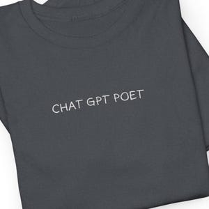 May include: A dark grey t-shirt with the text "CHAT GPT POET" printed in white on the front.