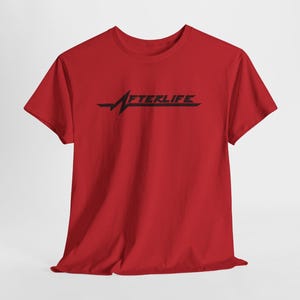 May include: A red t-shirt with the word "AFTERLIFE" in black, featuring a stylized heartbeat line design. The shirt is made of a soft material and has short sleeves.
