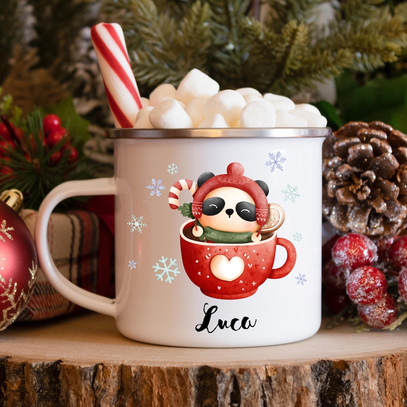 May include: White ceramic mug with a red and white panda bear design. The panda is wearing a red hat and holding a candy cane. The mug has the name "Luca" written on it.
