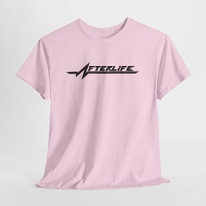 May include: A light pink t-shirt with the word "AFTERLIFE" in black, stylized text. The design includes a jagged line element. The shirt is made of a soft material.