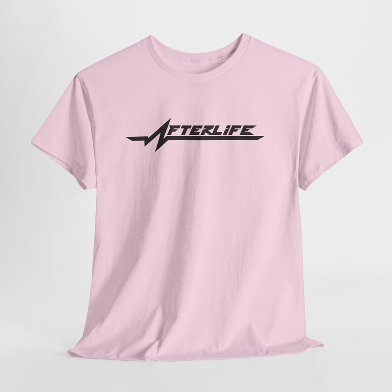 May include: A light pink t-shirt with the word "AFTERLIFE" in black, stylized text. The design includes a jagged line element. The shirt is made of a soft material.
