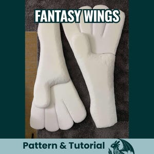 Puede incluir: Dos alas de fantasía blancas con una superficie texturizada, tumbadas sobre una superficie gris. El texto "FANTASY WINGS" está en la parte superior de la imagen. El texto "Pattern & Tutorial" está en la parte inferior.
