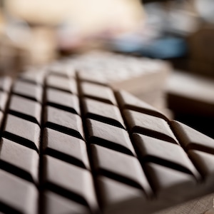 May include: Close-up of a wooden surface with a diamond-shaped pattern. The surface is made of multiple layers of wood, creating a textured look.