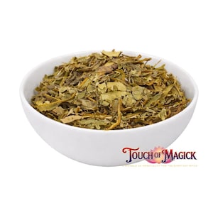 May include: A white ceramic bowl filled with dried green and brown herbs. The herbs have a leafy appearance. The bowl is set against a white background. The text "Touch of Magick" is in the bottom right corner.