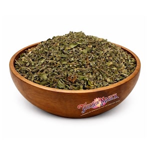 Peut inclure: Un bol en bois rempli d'herbes vertes séchées. Le bol a un grain de bois naturel et une forme incurvée. Le texte "Touch of Magick" est imprimé sur le côté du bol.