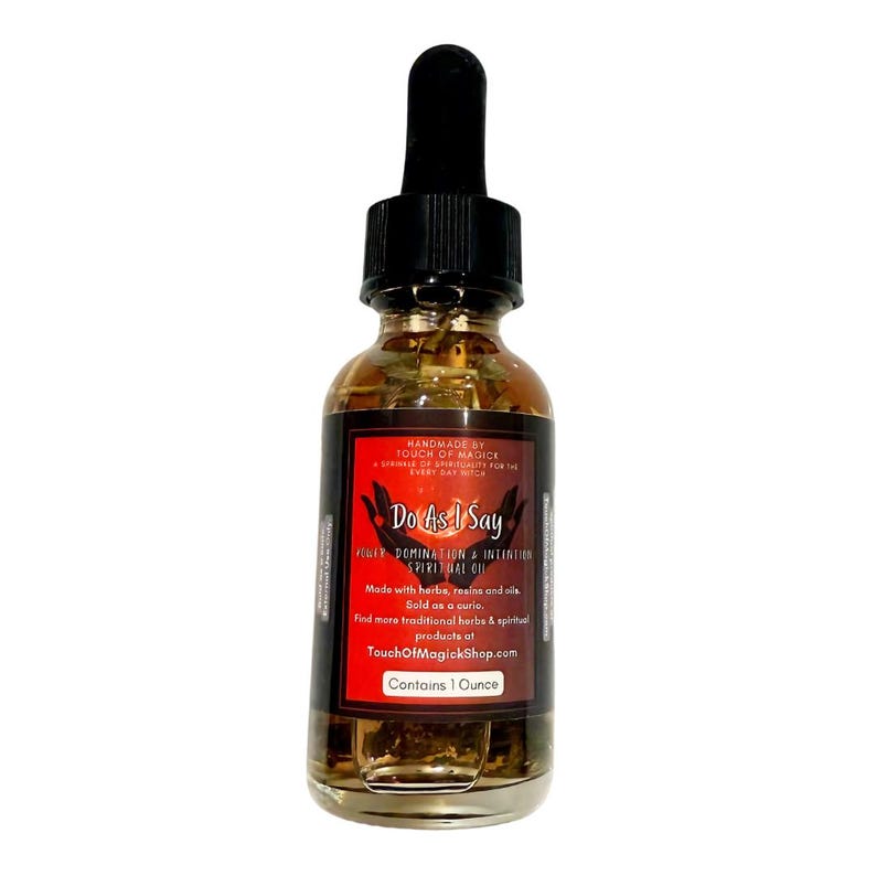 May include: A glass bottle of "Do As I Say" spiritual oil with a black dropper. The label is red and black, with text including "Power Domination & Intention Spiritual Oil" and "Contains 1 Ounce". The oil is amber-colored.