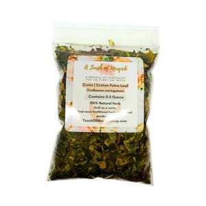 May include: A transparent bag containing dried Croton Petra Leaf. The label reads "A Touch of Magick" and lists the product name, botanical name, and weight of 14 grams. The text also states the product is a 100% natural herb.