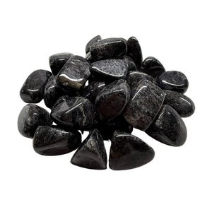 Pode incluir: Um monte de pedras de obsidiana preta polidas. As pedras são lisas e polidas, com uma aparência escura e vítrea.