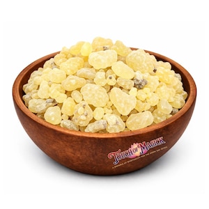 May include: A wooden bowl filled with pale yellow and tan resin pieces. The bowl has a dark brown exterior and the text "Touch of Magick" is visible on the side, along with the tagline "A sprinkle of spirituality for the every day witch."