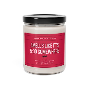 May include: A red candle jar with a black lid. The label reads "Happy Hour Collection" and "Smells Like It's 5:00 Somewhere". The label also includes a small illustration of two wine glasses and the text "9oz 50 hours save water and drink wine."