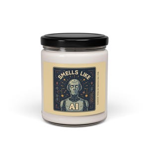 May include: A glass jar candle with a black lid. The label features a retro-style illustration of a robot with the text "SMELLS LIKE" above and "AI" below. The candle is advertised as having 50 hours of real scents.