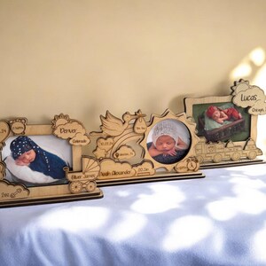 May include: Three wooden photo frames with baby pictures and personalized details. The frames are decorated with a stork, a rainbow, a sun, and a train. The frames are made of light brown wood and have a rustic look.