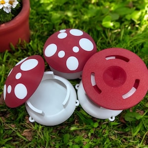 May include: Three red and white mushroom-shaped containers with white lids. The containers are made of plastic and have a speckled texture. The lids are smooth and have a slight lip around the edge.