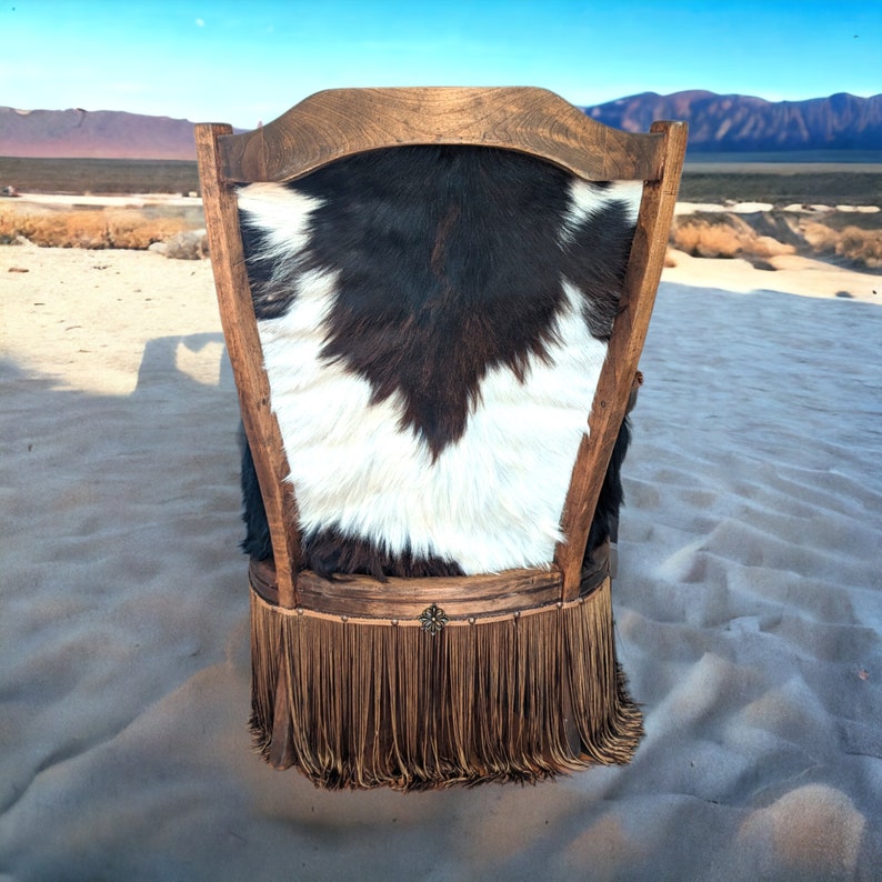 Elevate your farmhouse decor with this stunning Western Style Brown Leather Chair, a perfect blend of rustic charm and vintage appeal. Crafted from reclaimed wood and upcycled materials, this unique piece features a distressed brown leather frame that exudes cowboy cool. The upholstery is adorned with a striking Highland cow print, adding a touch of countryside authenticity, while the goat-skin hides drape gracefully over the seat, offering both comfort and texture.