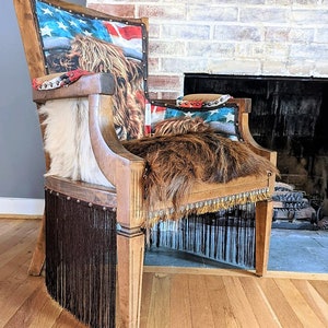 Elevate your farmhouse decor with this stunning Western Style Brown Leather Chair, a perfect blend of rustic charm and vintage appeal. Crafted from reclaimed wood and upcycled materials, this unique piece features a distressed brown leather frame that exudes cowboy cool. The upholstery is adorned with a striking Highland cow print, adding a touch of countryside authenticity, while the goat-skin hides drape gracefully over the seat, offering both comfort and texture.