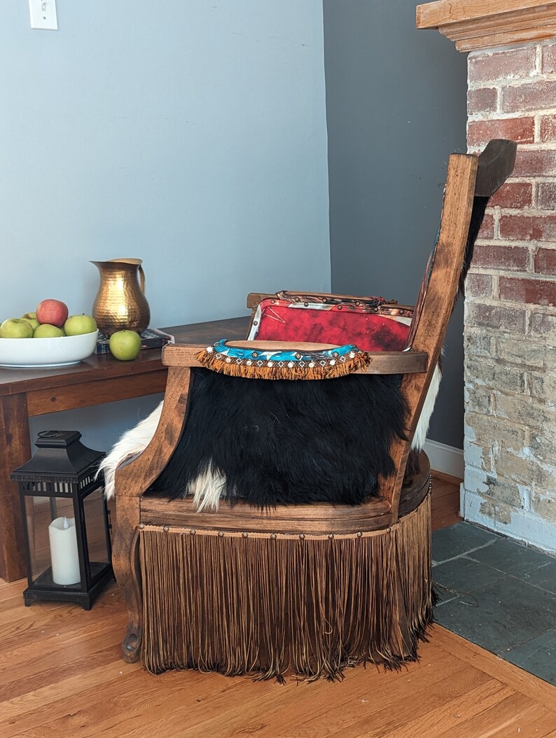 Elevate your farmhouse decor with this stunning Western Style Brown Leather Chair, a perfect blend of rustic charm and vintage appeal. Crafted from reclaimed wood and upcycled materials, this unique piece features a distressed brown leather frame that exudes cowboy cool. The upholstery is adorned with a striking Highland cow print, adding a touch of countryside authenticity, while the goat-skin hides drape gracefully over the seat, offering both comfort and texture.