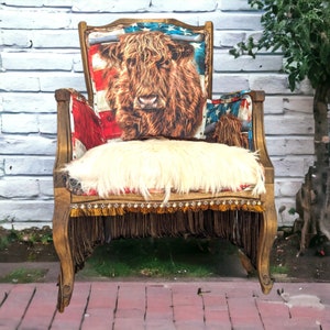 Elevate your farmhouse decor with this stunning Western Style Brown Leather Chair, a perfect blend of rustic charm and vintage appeal. Crafted from reclaimed wood and upcycled materials, this unique piece features a distressed brown leather frame that exudes cowboy cool. The upholstery is adorned with a striking Highland cow print, adding a touch of countryside authenticity, while the goat-skin hides drape gracefully over the seat, offering both comfort and texture.