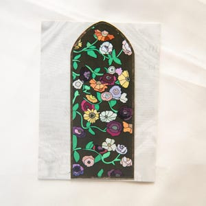May include: An arched panel with a floral design. The panel has a dark background with colourful flowers in shades of orange, yellow, pink, purple, and white, with green vines and leaves.