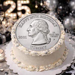 Könnte beinhalten: Ein runder, weiß glasierter Kuchen, verziert mit silbernen Streuseln und Zuckerguss. Der Kuchen ist mit einem großen, essbaren Bild eines silbernen Vierteldollars mit dem Text "Happy 25th Birthday" und dem Namen "Tommy" belegt. Die Zahl "25" ist im Hintergrund beleuchtet.