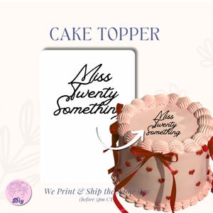 May include: A cake topper with the text "Miss Twenty Something" in a cursive font. The image shows the cake topper next to a pink cake decorated with red hearts and a red ribbon.