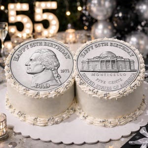 May include: Two white frosted cakes with silver bead trim. Each cake is topped with a large silver coin design that reads "Happy 55th Birthday." One coin features Thomas Jefferson and the word "DAD." The other coin shows Monticello.