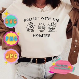 May include: White t-shirt with black text that reads "Rollin' with the Homies" and a graphic of three Star Wars characters: R2-D2, C-3PO, and BB-8.