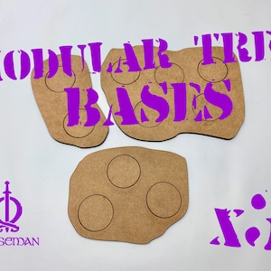 May include: Three modular tree bases made of brown wood, each with circular cutouts. The text "MODULAR TREE BASES" and "x3" are in purple. The Norseman logo is also in purple.