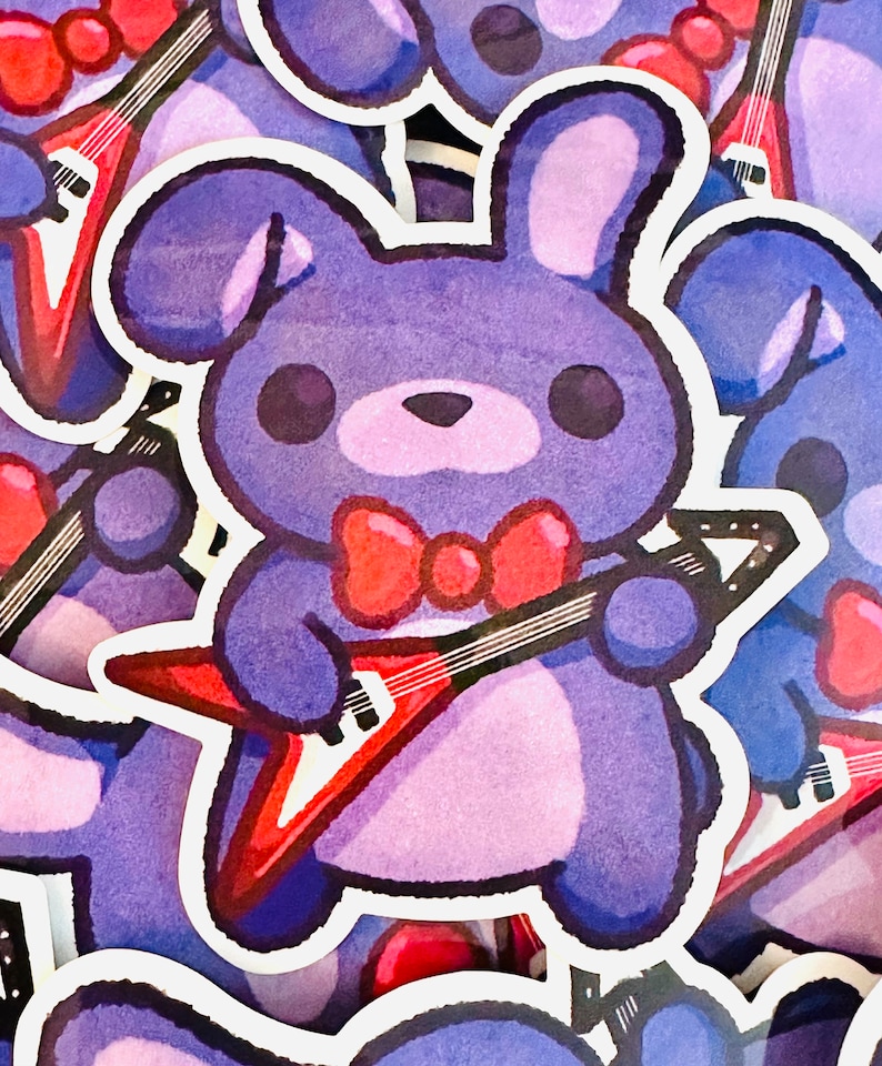 May include: A purple plush toy rabbit with a red bow tie is holding a red electric guitar. The toy is a sticker with a white outline.