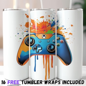 Puede incluir: Vaso blanco con un diseño de mando de videojuegos azul y naranja con salpicaduras de pintura. El texto "16 FREE TUMBLER WRAPS INCLUDED" está en la parte inferior. El vaso está diseñado para jugadores.