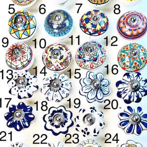 以下が含まれることがあります： 37個の装飾的なセラミックキャビネットノブのコレクション。ノブは、花柄、幾何学模様、抽象的なモチーフなど、さまざまなデザインが特徴です。カラーパレットには、白、青、金、オレンジ、黄色が含まれます。各ノブには、取り付け用の金属ネジが付いています。