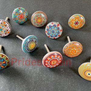 May include: Assortment of ten colorful ceramic cabinet knobs with intricate mandala designs. Each knob features a different pattern with shades of blue, green, orange, red, and yellow.