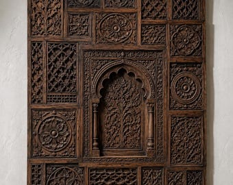 May include: A large rectangular dark brown wooden wall panel featuring intricate hand-carved relief patterns. The design consists of multiple square and rectangular sections with floral motifs, geometric lattice work, and a central arched niche.
