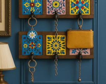 May include: A wooden key holder with six decorative ceramic tiles featuring floral patterns in blue, yellow, and pink. The key holder has metal hooks and chains for keys and a small yellow wallet.