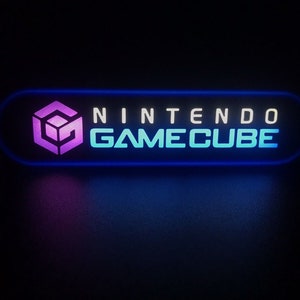 May include: A blue and white neon sign with the text "NINTENDO GAMECUBE" and a purple and white Nintendo GameCube logo.
