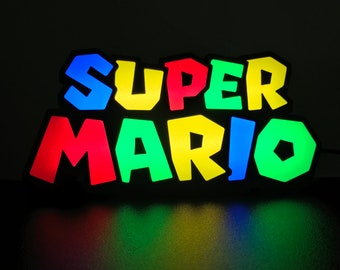 May include: A colorful light-up sign that reads "SUPER MARIO" in a retro video game style. The letters are outlined in black and each letter is a different color: blue, yellow, red, green, and blue.