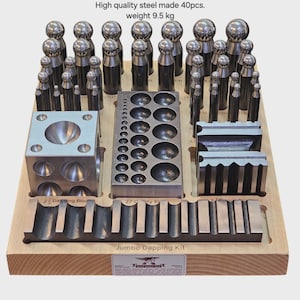 Könnte beinhalten: Eine Holzablage mit einem Satz von Schmuckherstellungswerkzeugen aus Stahl. Das Set enthält Prägeblöcke, Stempel und Formwerkzeuge. Der Text auf dem Tablett lautet "Jumbo Dapping Kit". Das Bild enthält auch den Text "High quality steel made 40pcs. weight 9.5 kg."